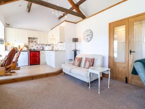 a living room with a white couch and a kitchen at Bay View Apartment in Porthmadog