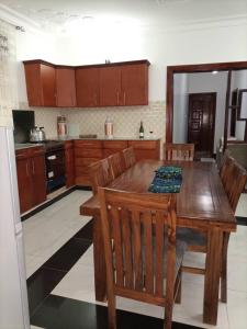 a kitchen with a wooden table and wooden cabinets at Villa Bunyonyi in Kabale