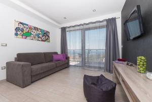 a living room with a couch and a large window at Villa Steffi in Baška Voda
