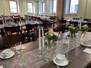 a dining room with tables and chairs with flowers and candles at BürgerhausLöwen in Philippsburg