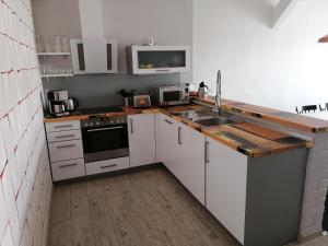 a kitchen with white cabinets and a sink and a microwave at Central Loft Apartment in Ueckermünde