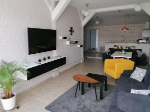 uma sala de estar com televisão numa parede de tijolos brancos em Central Loft Apartment em Ueckermünde