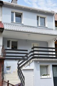 ein weißes Haus mit einer Treppe davor in der Unterkunft Pokoje Gościnne Orla 4 i in Misdroy
