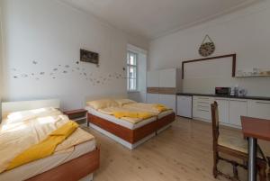 2 Betten in einem Zimmer mit einer Küche und einem Tisch in der Unterkunft Vratislavsky Dum in Třeboň