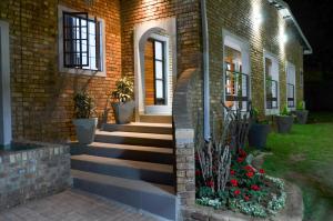 威特班克的住宿－雅拉雅拉精品酒店，院子里的砖房,有楼梯和鲜花