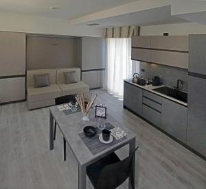 a living room with a table and a kitchen at Residence Eden & Spa in Gabicce Mare +10 photos
