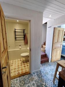 a bathroom with a tub and a toilet and stairs at Villa Reuter in Stormälö