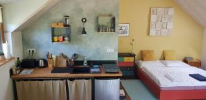 a bedroom with a bed and a desk with a laptop at DOMČEK V ZÁHRADE in Banská Štiavnica