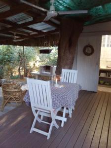 two white chairs and a table on a deck at Lebombo Wattle Cottage - Forest 1 in Hluhluwe