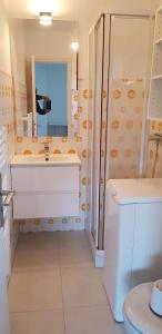 Un baño blanco con lavabo y ducha. en Studio avec terrasse 2 personnes, en Le Lavandou