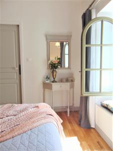 a bedroom with a bed and a mirror and a table at La Maison Verte in Siorac-de-Ribérac