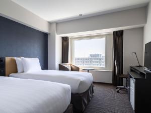 Cette chambre comprend 2 lits et une fenêtre. dans l'établissement ANA Crowne Plaza Sapporo, an IHG Hotel, à Sapporo