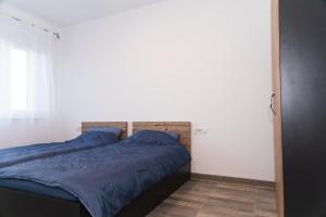 1 cama con sábanas azules en una habitación con ventana en Apartament West, en Oradea