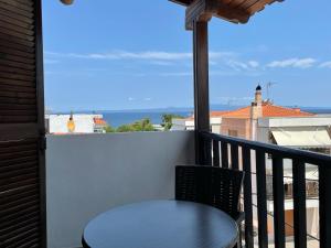 uma mesa e cadeira numa varanda com vista para o oceano em Hotel Castelli em Kallithea Halkidikis