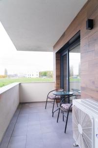 balcón con mesa, sillas y ventana en Apartament West, en Oradea