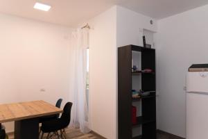オラデアにあるApartament Westのテーブルと冷蔵庫のあるダイニングルーム +7枚の写真