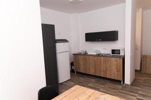a room with a kitchen with a refrigerator and a microwave at Apartament West in Oradea