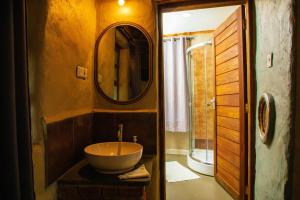 a bathroom with a bowl sink and a mirror at Kutoka Lodge in Arusha +152 photos