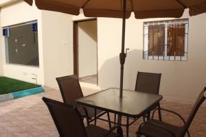 a table and chairs with an umbrella in a room at Marka resort ماركاريزورت in Abha