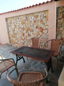 a table and chairs in front of a stone wall at Студия Синя приказка in Sozopol