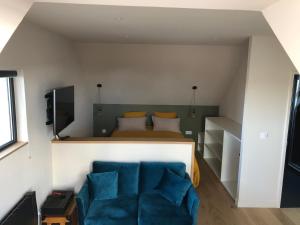 勒孔凱的住宿－Appartement L'Embarcadère，一间卧室配有一张床和一张蓝色的沙发