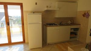 una cucina con frigorifero bianco e finestra di B&B Nereidi a Melito di Porto Salvo