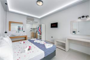 a white bedroom with a bed and a sink at Breeze Luxury Rooms in Laganas
