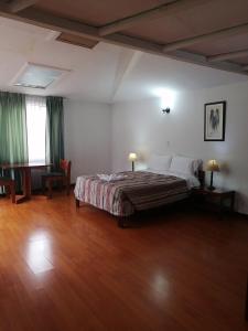 1 dormitorio con 1 cama grande y suelo de madera en Room in Guest room - Amazing Junior Suite Close The Airport And Trade Center, en Bogotá
