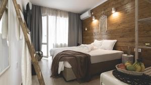a bedroom with a bed with a wooden wall at La Finca - Saint Vlas in Sveti Vlas