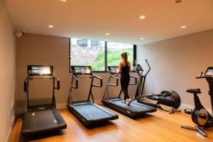 a woman is walking on treadmills in a gym at Hotel Les Haras in Strasbourg