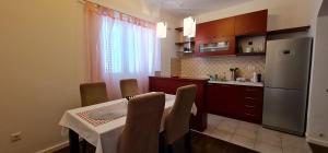 y cocina con mesa, sillas y nevera. en Apartman Breza en Šibenik