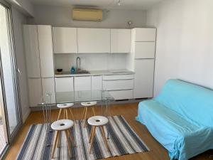 a small kitchen with a couch and a table in a room at Studio vue mer in Beaulieu-sur-Mer