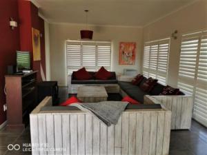a living room with a large couch and a table at Mystic Breeze in Hermanus