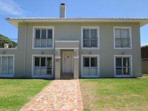 a large white house with a lawn in front of it at Mystic Breeze in Hermanus