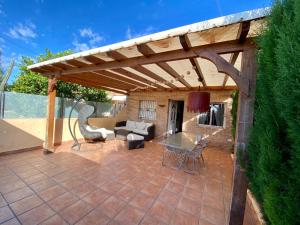 eine Terrasse mit einer hölzernen Pergola mit einem Tisch und Stühlen in der Unterkunft Dos Mares Comfort & Calidad- Casa entera Planta Baja in San Javier
