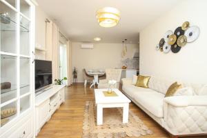 un soggiorno con un divano bianco e un tavolo di Villa 3D by the Sea with pool and included breakfast a Kaštela (Castelli)