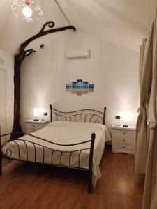 een slaapkamer met een bed en een boom aan de muur bij Casa Janas Affittacamere Bed & Breakfast in Piscinas