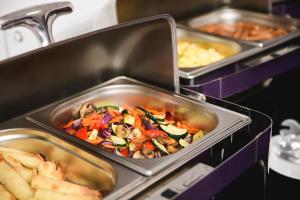 ein Buffet mit Speisen in Metalltablett in der Unterkunft Best Western Plus Hotel Olsztyn Old Town in Olsztyn