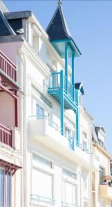 un edificio blanco con balcones azules en Villa le Courlis Panoramic see view, en Ault