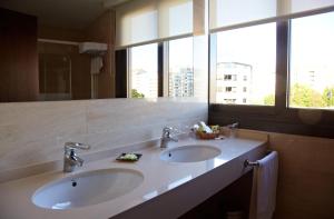 a bathroom with two sinks and a large window at Hotel Coia de Vigo in Vigo
