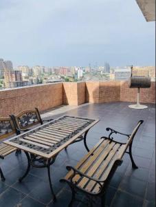 a patio with two benches and a table on a roof at BEST VIEW APARTMENT WITH TERRACE in Baku