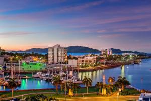 eine Stadt mit Booten in einem Jachthafen nachts in der Unterkunft Allure Hotel & Apartments in Townsville