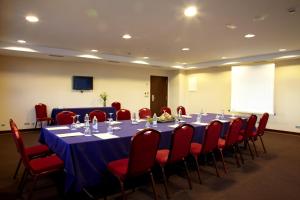 a conference room with a blue table and red chairs at Hotel Coia de Vigo in Vigo