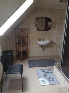 ein Bad im Dachgeschoss mit einem Waschbecken und einem Waschbecken in der Unterkunft Helene in Loxstedt