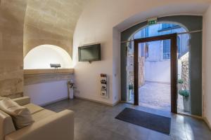 a living room with a couch and a tv at Hotel Vittorio Veneto in Ragusa