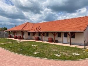 a building with an orange roof and a yard at Tisza-i Apartmanok in Tiszafüred