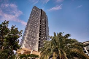 a tall building with a palm tree in front of it at Encore Broadbeach in Gold Coast
