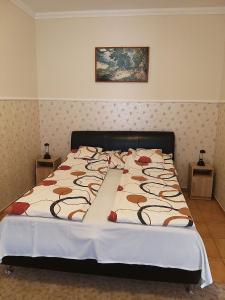 duże łóżko w sypialni z dwoma stołami w obiekcie Garden Apartmanház 2 w Hajduszoboszlo