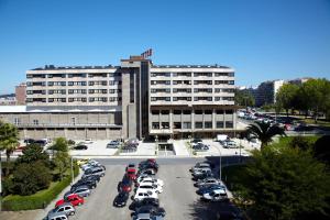 um parque de estacionamento em frente a um grande edifício em Hotel Coia de Vigo em Vigo
