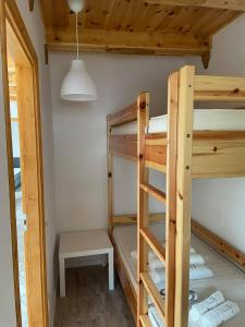a room with two bunk beds and a table at Tisza-i Apartmanok in Tiszafüred
